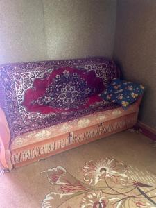 a bed with a purple blanket on top of it at Домики in Borovoye