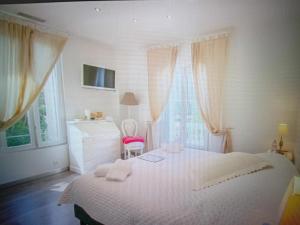 a white bedroom with a bed and windows at Chic Villa Webb Cannes in Cannes
