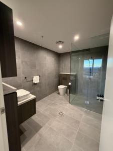 a bathroom with a toilet and a glass shower at Luxurious City View with Gym Pool Parking Playground in Sydney