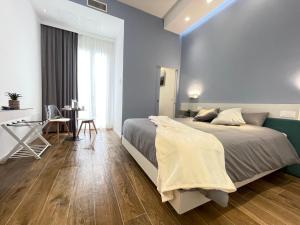a bedroom with a large bed and a desk at Alloggio degli Eroi by LocazioniOK in Mola di Bari