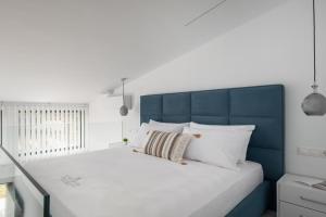 a bed with a blue headboard and white pillows at Mini Boutique Dragani in Sykia Chalkidikis +26 photos