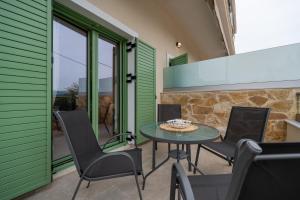 a patio with a table and chairs and a stone wall at Asini deluxe suite 3, with rooftop terrace and breathtaking views in Asíni