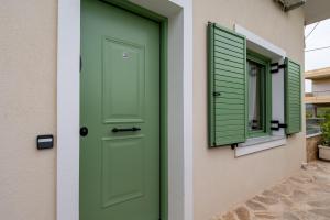 a green door and window on a house at Asini deluxe suite 3, with rooftop terrace and breathtaking views in Asíni
