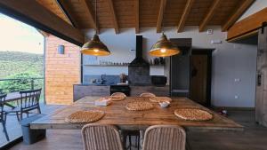 a kitchen with a wooden table with chairs and a dining room at La Finca del Valle in Valle de Vegacervera +12 photos