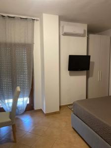 a bedroom with a bed and a tv and a chair at B&B Olimpia in Cosenza