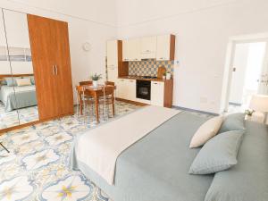 a bedroom with a large bed and a kitchen at Maridea - Chiaia di Luna in Ponza +10 photos