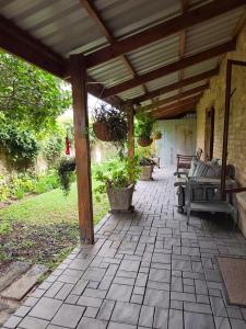 an outdoor patio with benches and a wooden pergola at Serendipity Garden Studio Gateway to Kruger and Panorama Route in Kampersrus AH