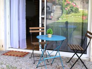 a blue table with two chairs and a potted plant at Stripe Studio in Bonne-sur-Ménoge