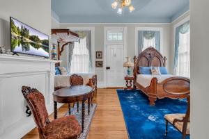a bedroom with two beds and a blue rug at The Montgomery B&B in Starkville