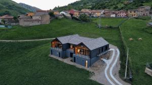 a small house on a hill with a road at La Finca del Valle in Valle de Vegacervera