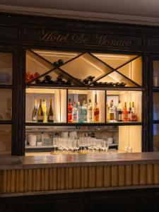 eine Bar mit Gläsern und Flaschen Alkohol in der Unterkunft Hotel De Monaco in Cap d'Ail
