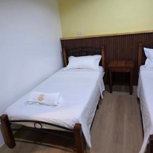 a bedroom with two beds with white sheets at Sunflower Residences Capitol formerly mayflower inn in Cebu City