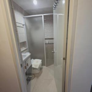 a small bathroom with a toilet and a shower at Sunflower Residences Capitol formerly mayflower inn in Cebu City +6 photos