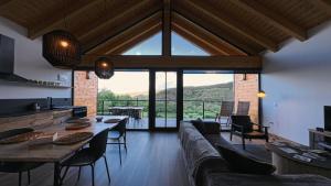 a living room with a long couch and a large window at La Finca del Valle in Valle de Vegacervera