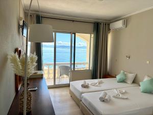 a bedroom with two beds with a view of the ocean at IONIAN MARE in Agios Ioannis Peristerion