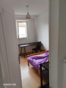 a room with a bed and a table and a window at Ecolocs Caen Beuville in Caen