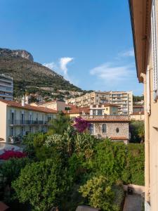 Blick auf eine Stadt mit einem Berg im Hintergrund in der Unterkunft Hotel De Monaco in Cap d'Ail