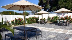 a patio with tables and chairs and umbrellas at Regent Heights Hotel in Johannesburg
