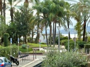 a parking lot with palm trees and a motorcycle at Appartement centrale à 100 m des plages Rue de Provence in Saint-Raphaël