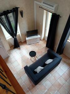 a living room with a blue couch and a chair at Le Mas Gabantelye in Saint-Paulet-de-Caisson +18 photos