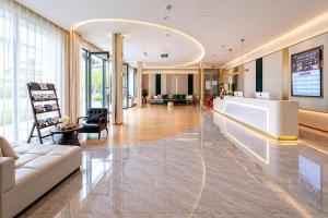 an office lobby with a white couch and a desk at Tuke Light Hotel Jiuzhaigou 途客轻居酒店九寨沟店 in Jiuzhaigou