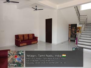 a living room with a couch and a ceiling fan at Nilavoor in Yelagiri