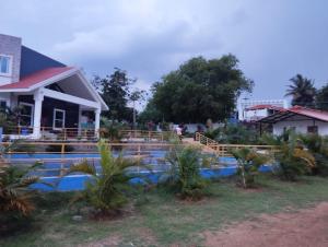 a house with a swimming pool in front of a house at Nilavoor in Yelagiri