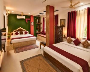 a bedroom with two beds and a green wall at The Hideout Agra Garden Homestay - Near Taj Mahal in Agra +42 photos