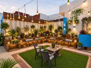 a patio with plants and tables and chairs at The Hideout Agra Garden Homestay - Near Taj Mahal in Agra