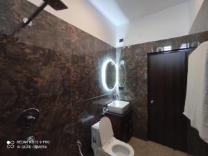 a bathroom with a toilet and a sink at Glotus Hotel in Herbertpur