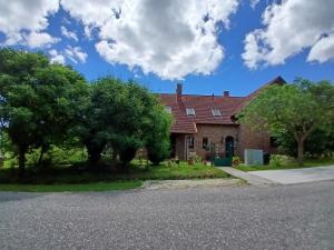 a brick house with trees in front of it at Mami Apartman in Zalakaros