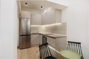 a kitchen with a glass table and a stainless steel refrigerator at No7 Pool House in Iraklitsa