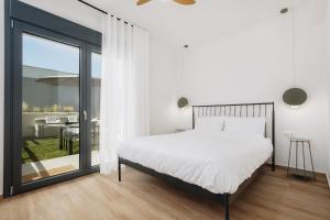 a bedroom with a bed and a sliding glass door at No7 Pool House in Iraklitsa +26 photos