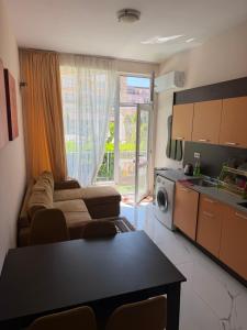 a living room with a couch and a kitchen with a window at Центр солнечного берега in Sunny Beach