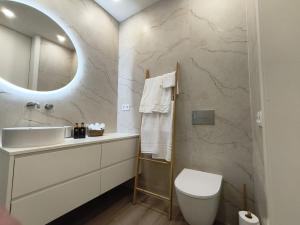 a bathroom with a sink and a toilet and a mirror at Cidral Path 32 in Póvoa de Varzim