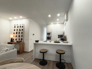 a kitchen with a counter and stools in a room at Cidral Path 32 in Póvoa de Varzim +25 photos