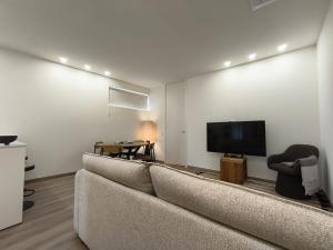 a living room with a couch and a flat screen tv at Cidral Path 32 in Póvoa de Varzim