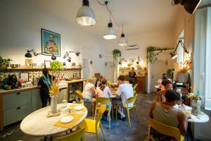 a group of people sitting at tables in a restaurant at Borgo Vergini Garden B&B in Naples