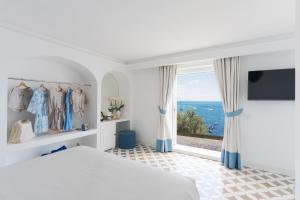 a bedroom with a bed and a large window at Casa Fioravante in Positano