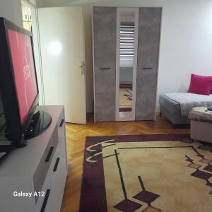 a living room with a tv and a bedroom at Apartman Suva reka in Leskovac