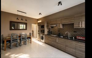 a kitchen with wooden cabinets and a table and chairs at Beach luxury Penthouse in Flic-en-Flac