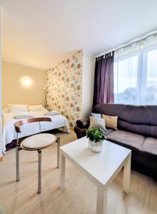 a living room with a bed and a couch at PATIO dom gościnny in Łukęcin