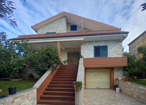 a house with a staircase leading to a garage at Vila Relax, Manez Durrës in Manzë