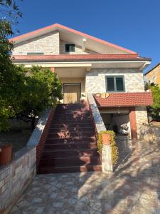 a house with stairs leading to the front door at Vila Relax, Manez Durrës in Manzë