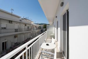 a balcony with a table and chairs on a building at Milva Apartments in Kos