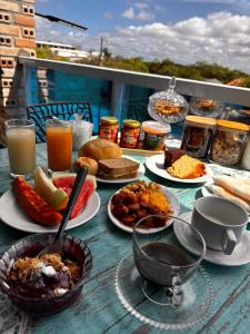 a table topped with plates of food and drinks at Pousada Imperio Azul in Santo Amaro