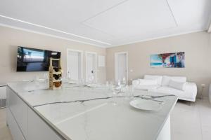 a white living room with a table and a couch at Meganisi Villas Royal in Meganisi