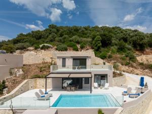 a house on a hill with a swimming pool at Meganisi Villas Royal in Meganisi