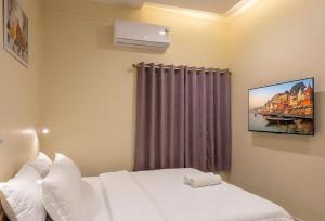 a bedroom with a bed with a tv on the wall at Ratnadeep Palace - Near Kashi Vishwanath Temple & Ghats in Varanasi