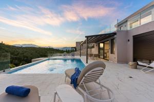 a house with a swimming pool and two chairs at Meganisi Villas Royal in Meganisi